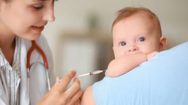 Bronchiolite : quand vacciner en 2025 ? Image d'une infirmière avec une seringue dans la main devant un nourrisson..