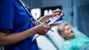 Grippe : épidémie sévère et mortelle en 2025 : une soignante au chevet d'une personne âgée allongée sur un lit d'hôpital.