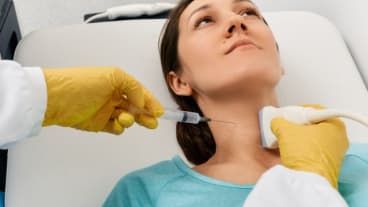 Comment detecter un cancer ? Biopsie de la glande thyroïde : aspiration avec une fine aiguille au niveau du cou d'une jeune-femme.