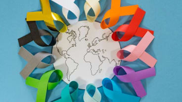 Journée mondiale contre le cancer 2025. Image d'une planète entourée de ruban de multiples couleurs.