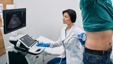 Quel est le meilleur examen pour les reins ? Image d'un patient chemise levée pour pendant qu'une soignante examine ses reins à l'échographie.