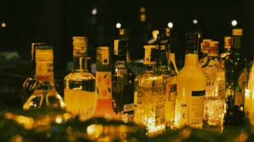 Est-ce que l'alcool peut provoquer un cancer du pancréas ? Image d'une table de bar où figurent plusieurs bouteilles d'alcool la nuit. Licence Creatives Commons pexels-holoshuriken.