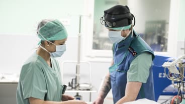 Un chirurgien en train de se préparer à opérer. Une infirmière l'aide.