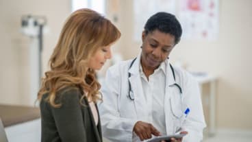 Santé des femmes : une soignante montre un document à une patiente dans une salle de soins.
