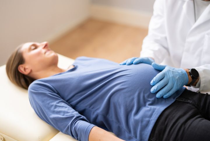 Accouchement par le siège : image d'une femme enceinte, allongée sur une table médicale, accompagnée de son médecin