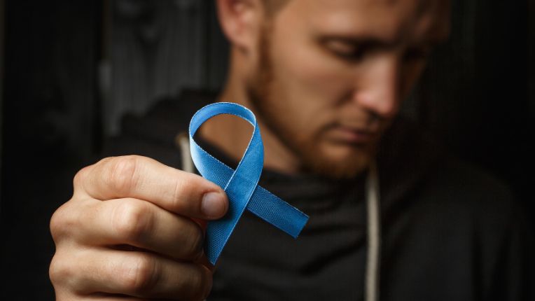 Homme en arrière plan , avec un ruban bleu en signe du cancer du sein chez l'homme
