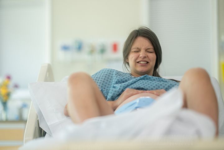 Accouchement sans péridurale : femme enceinte allongée durant le travail.