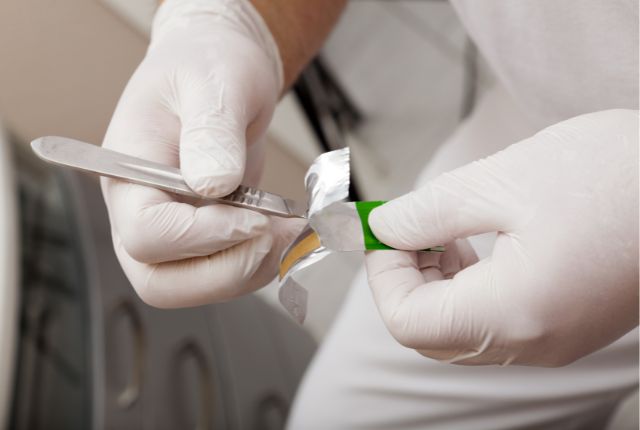 bistouri à usage unique extrait de son emballage par un chirurgien en vue d'une exérèse