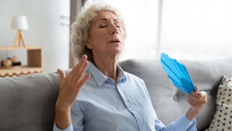 Canicule et fortes chaleurs : conseils de prévention. Image d'une femme qui se ventile avec un éventail.