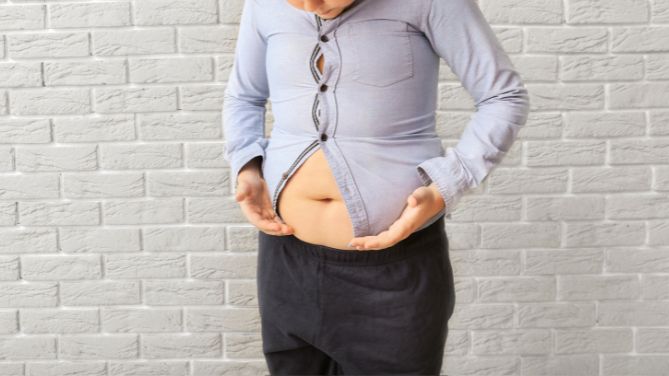 Journée nationale de dépistage de l'obésité infantile. Un jeune garçon n'arrive plus à boutonner sa chemise sur son ventre un peu proéminent.