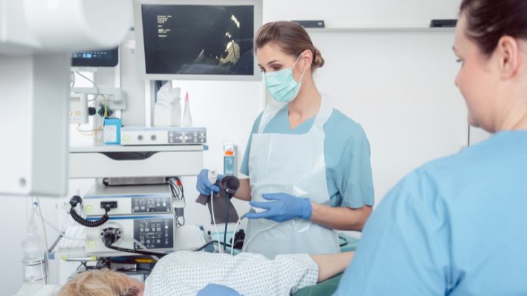 Opération de l'estomac par robot à Brest. Deux soignantes préparent une patiente à un examen de l'estomac.