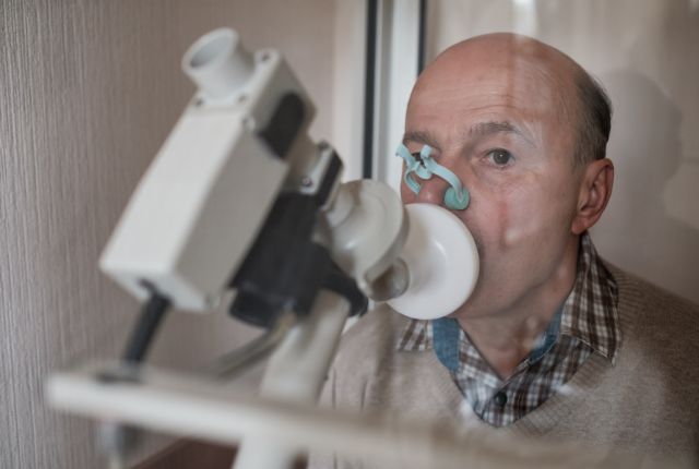 Exploration fonctionnelle respiratoire (EFR) : un homme avec une pince sur le nez souffle dans un tube (spirométrie).