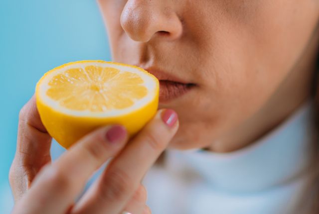 Anosmie : une femme renifle un citron.