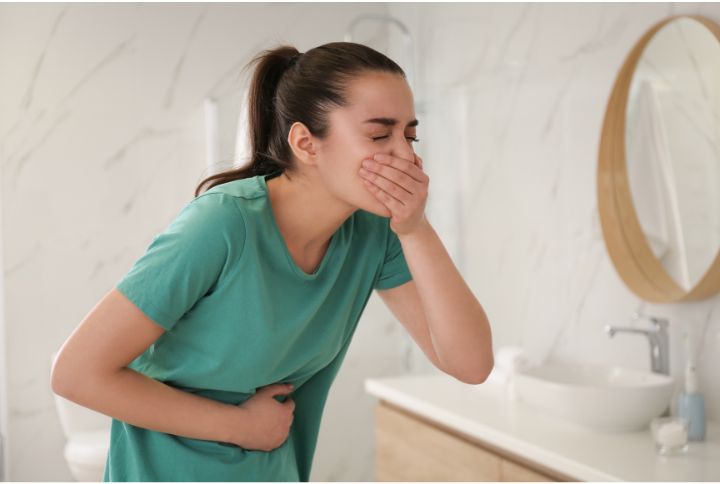 Cancer du cardia : pathologie et traitement. Image d'une femme se tenant le ventre, souffrant de douleurs à l'estomac.