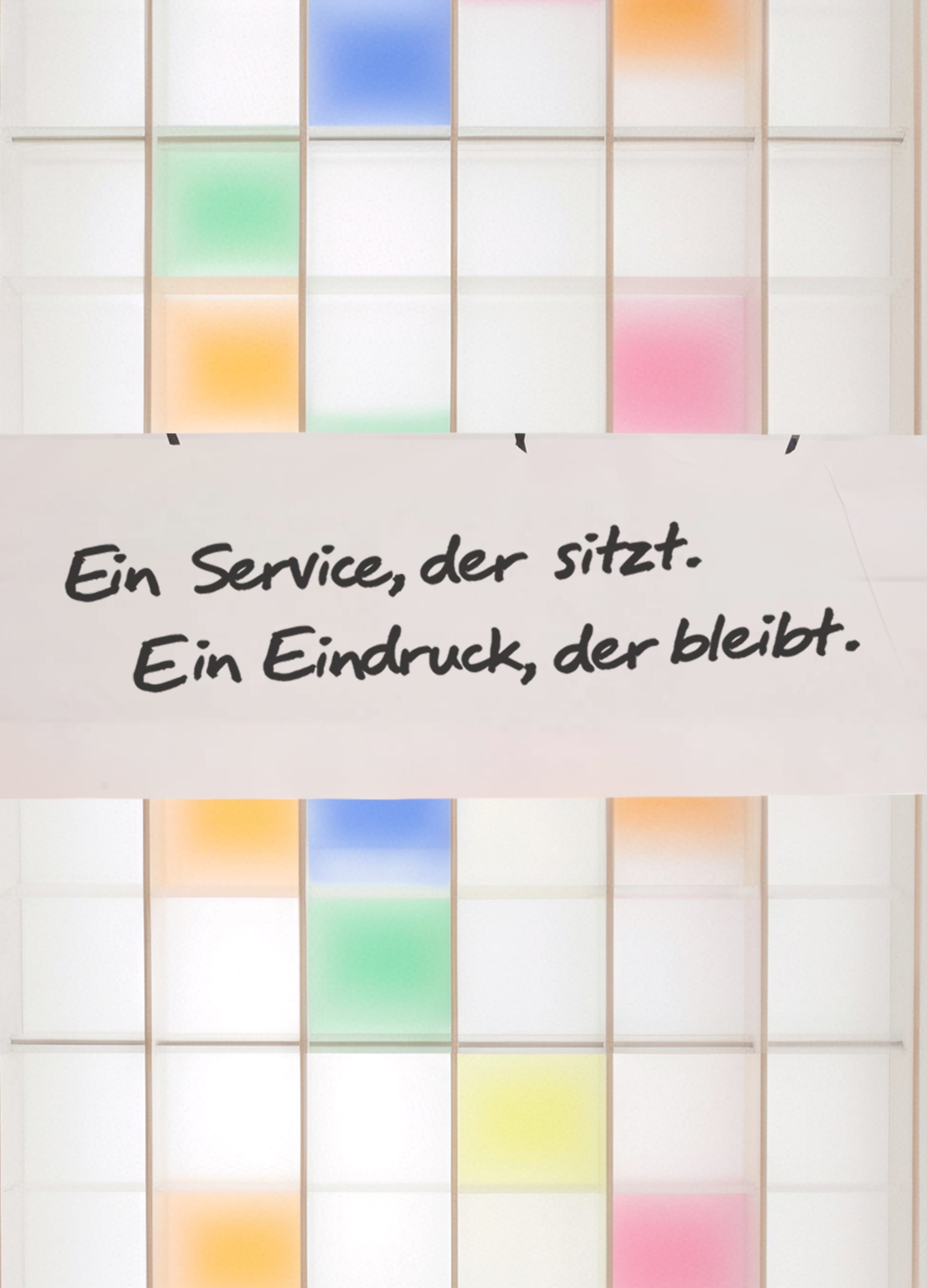 Ein weißes Regal mit bunten Abteilungen. An dem Regal hängt ein Papier mit einem Spruch: Ein Service, der sitzt. Ein Eindruck, der bleibt.