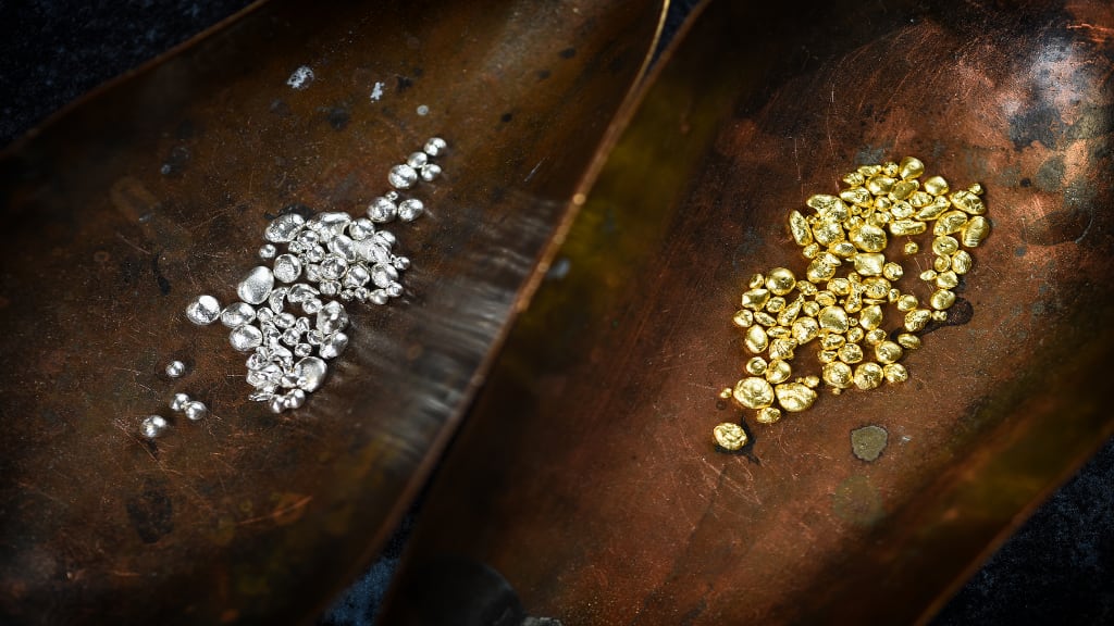 Zwei Schalen voll mit Gold- und Silbergranulat