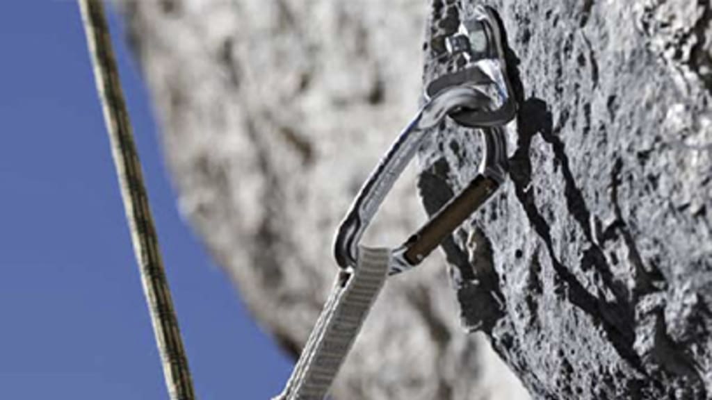 Steinwand mit einem Kletterkarabiner