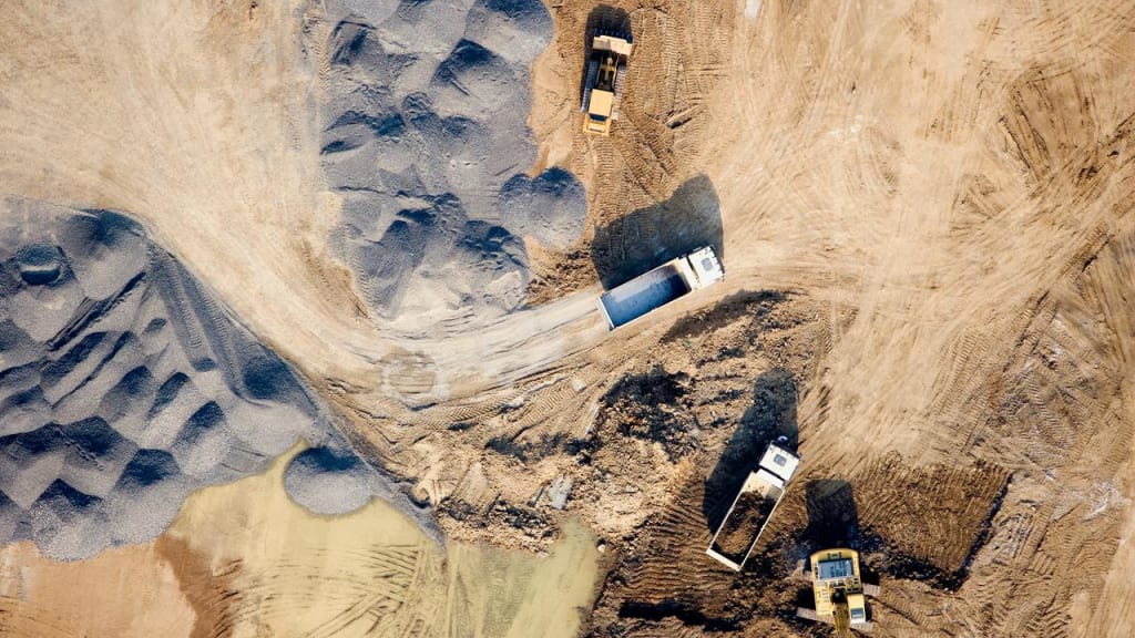 Industriområde med gravemaskiner og lastbiler 