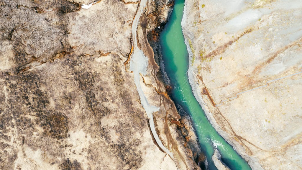 Flusslauf mit Niedrigwasser und Sand und vertrockneter Landschaft