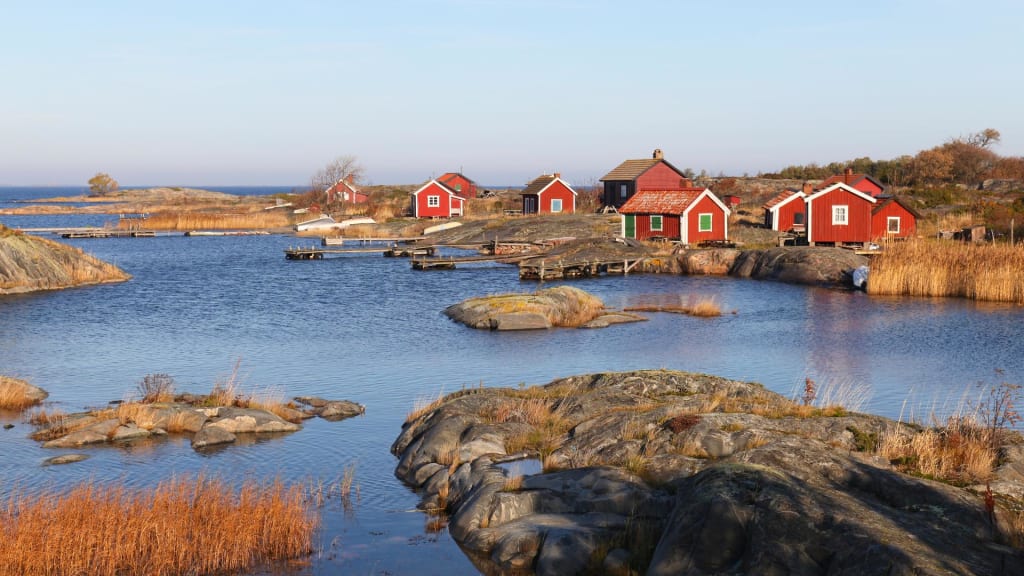 Small red cottages in autumn in outer archipelago of Stockholm.