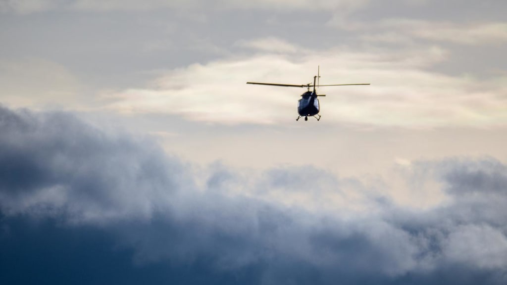 En helikopter flyver over skyerne