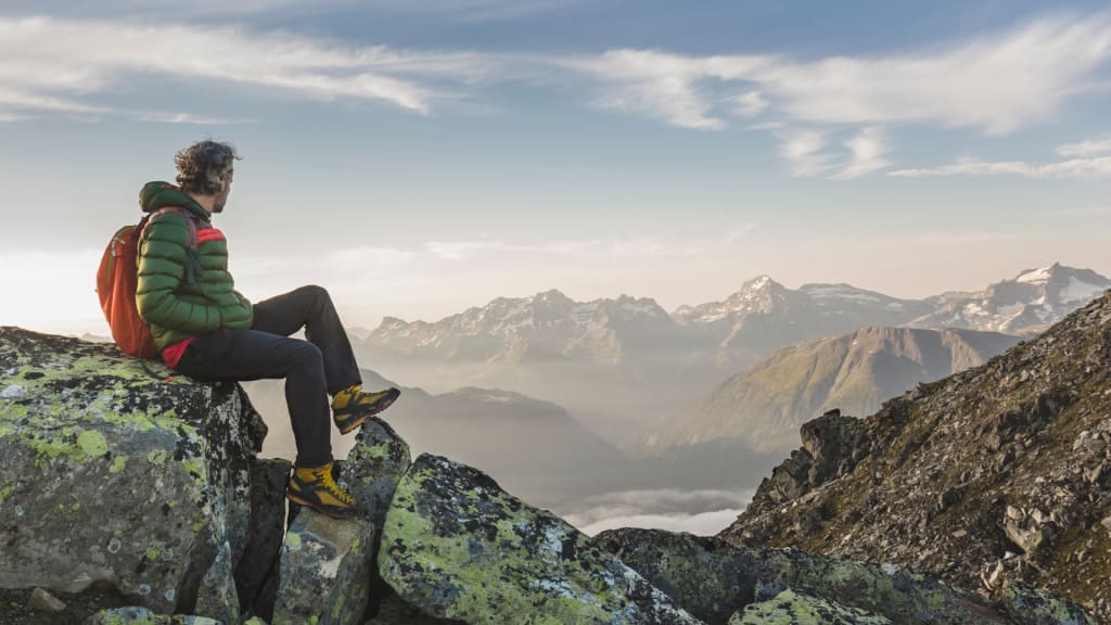 Wanderer auf dem Berggipfel: Leistung, Abenteuer und schöne Aussichten