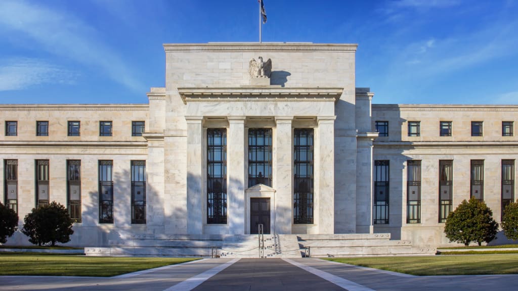 Exterior of the Federal Reserve building with white stone façade and columns.