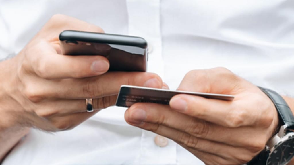 Mann mit Handy und Kreditkarte