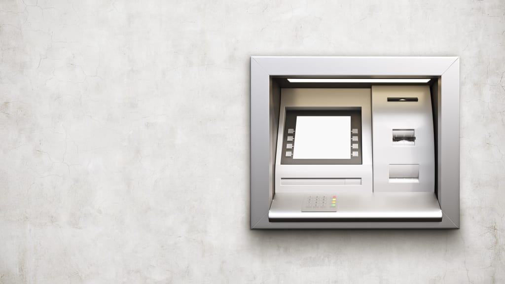 Silbrigen Bankautomat auf weissen Wand