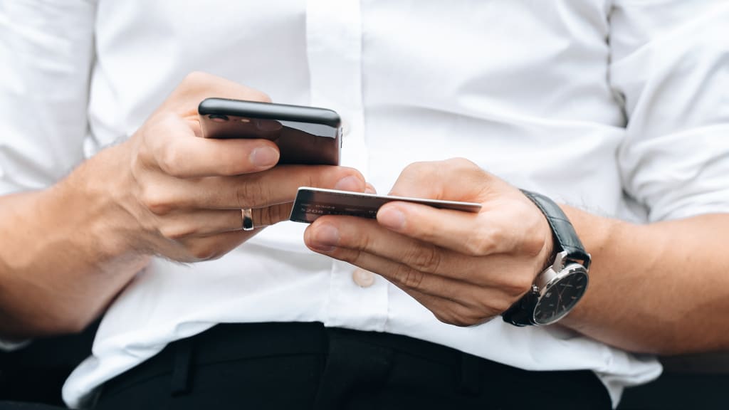 Mann mit Handy und Bankkarte Nahaufnahme 