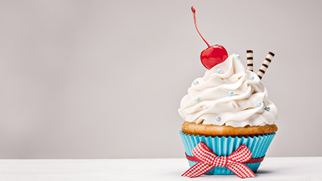 Fotos eines stark verzierten Cupcakes.