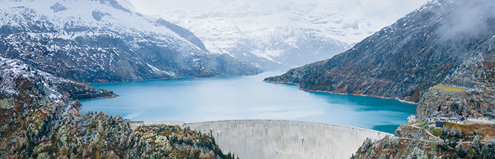 Panoramaphoto eines Staudamms in einer bergigen Landschaft