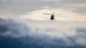 En helikopter flyver over skyerne