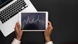 Hands with laptop and price chart