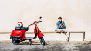Ragazzo italiano con motorino e casco tricolore