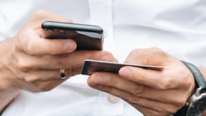 Mann mit Handy und Kreditkarte