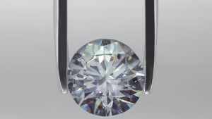 Ein silbrigen Diamant im Fokus und eine Pinzette