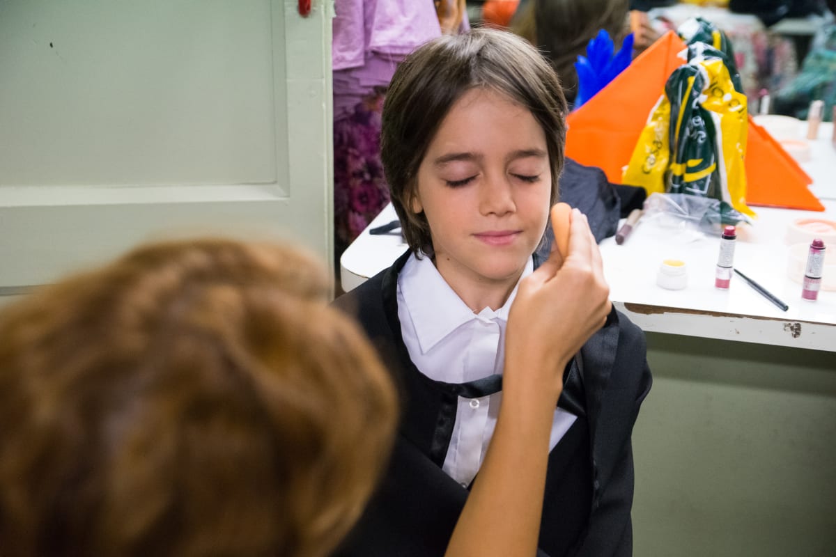 Maquillaje en los camerinos antes de la función, con el vestuario colgado al fondo