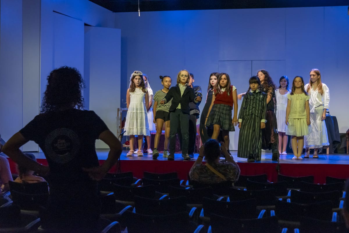 Assaig a la sala: alumnes alineades a l'escenari davant la platea buida