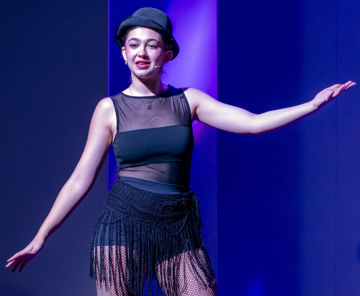 Escena de Chicago: una intérprete con bombín y vestido negro de flecos