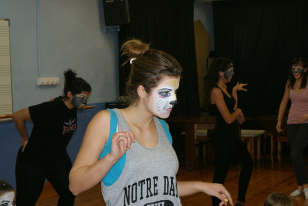 Ensayo en el aula con maquillaje felino y movimiento de danza
