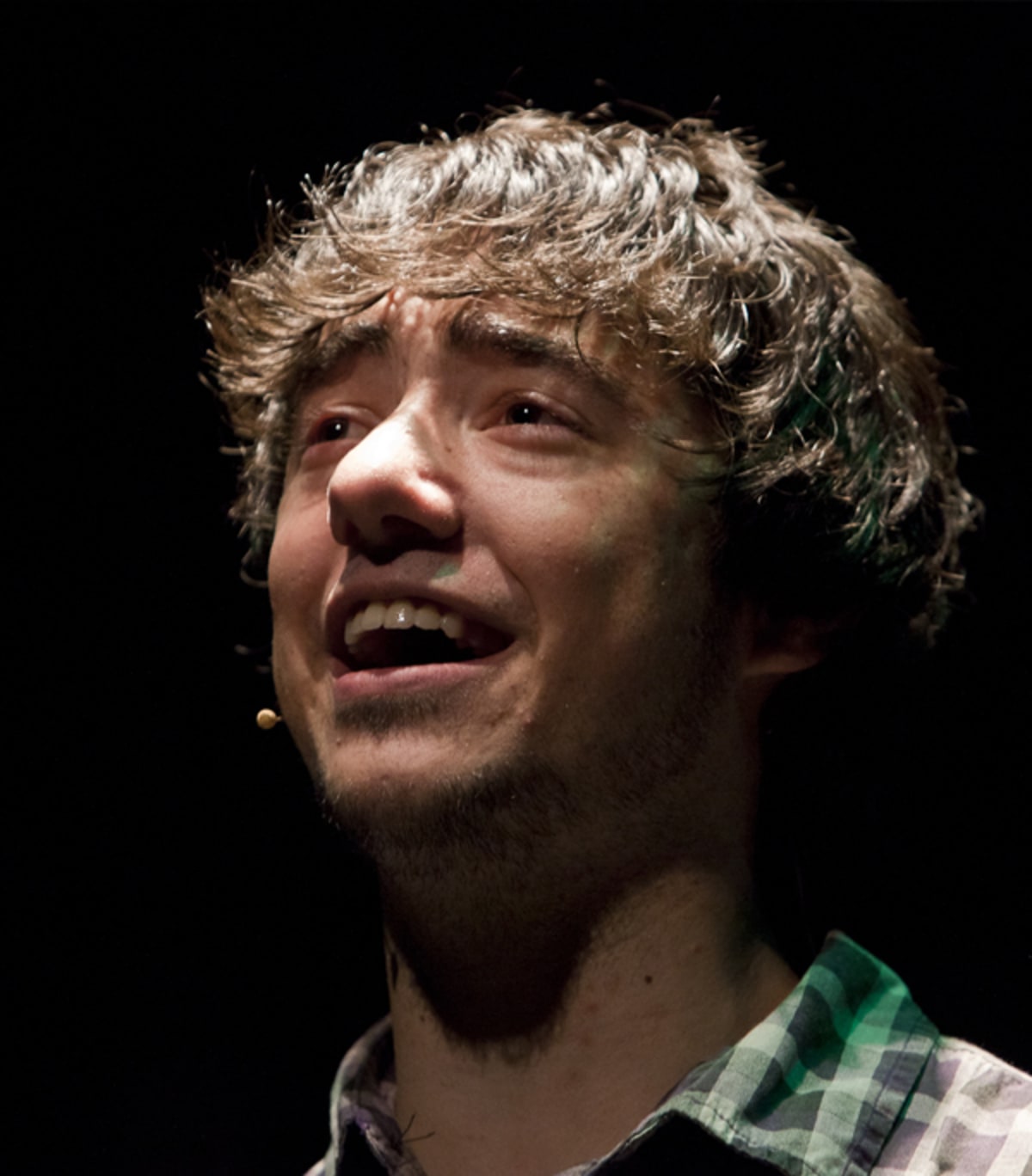 Primer pla d'un actor amb micròfon de diadema cantant amb expressió intensa