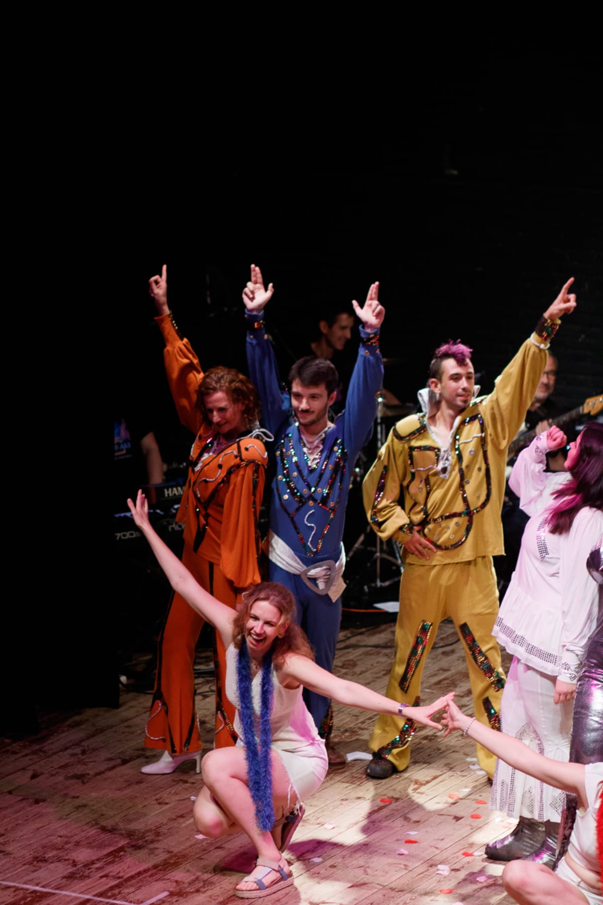 Final de Mamma Mia con monos brillantes de los años setenta y confeti