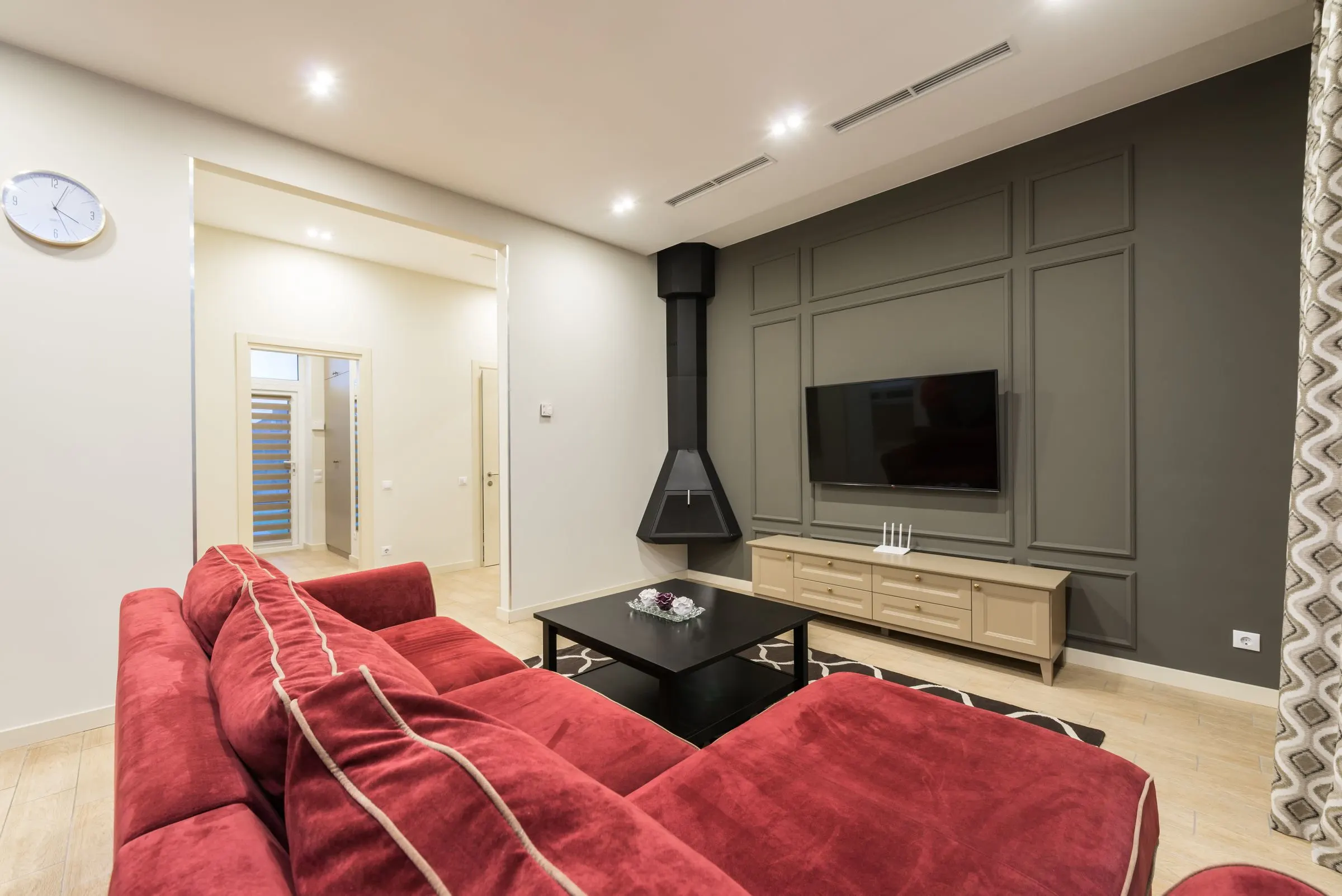 Modern living room with a wall-mounted television and connected smart-home devices