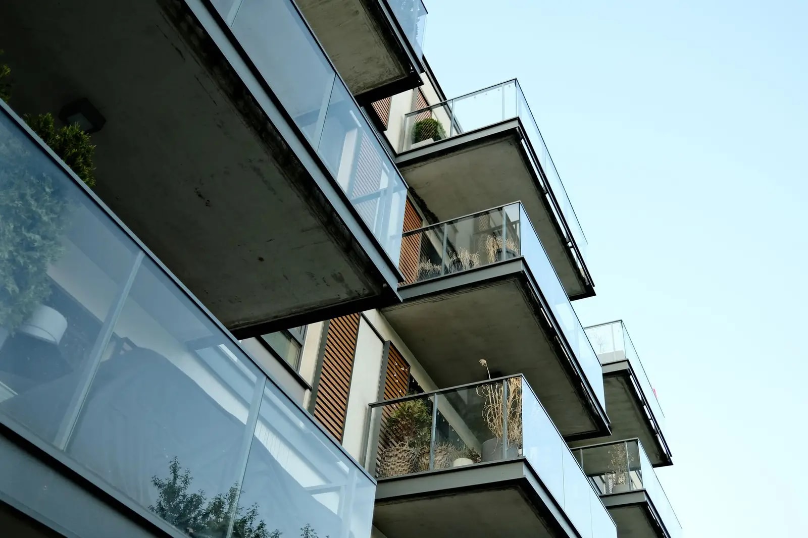 Glass-fronted balconies stacked along the side of a modern apartment building