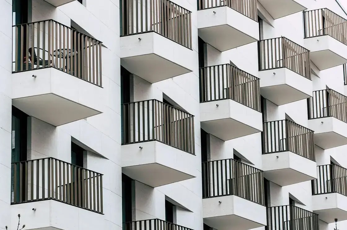 Balconies stacked in an offset pattern across the facade of a modern apartment building