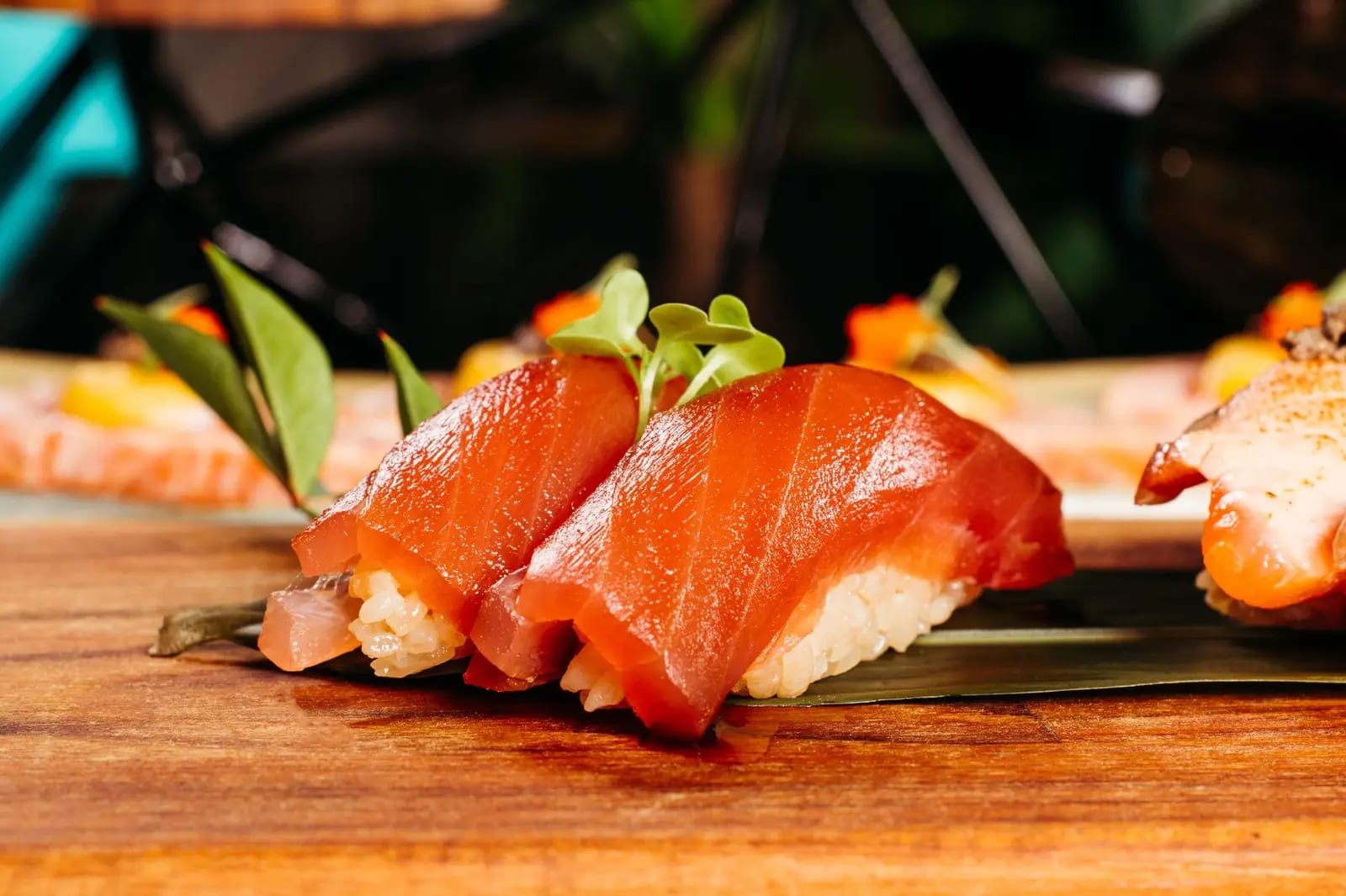 Delicious slices of salmon nigiri sushi served beautifully on a wooden platter with garnish