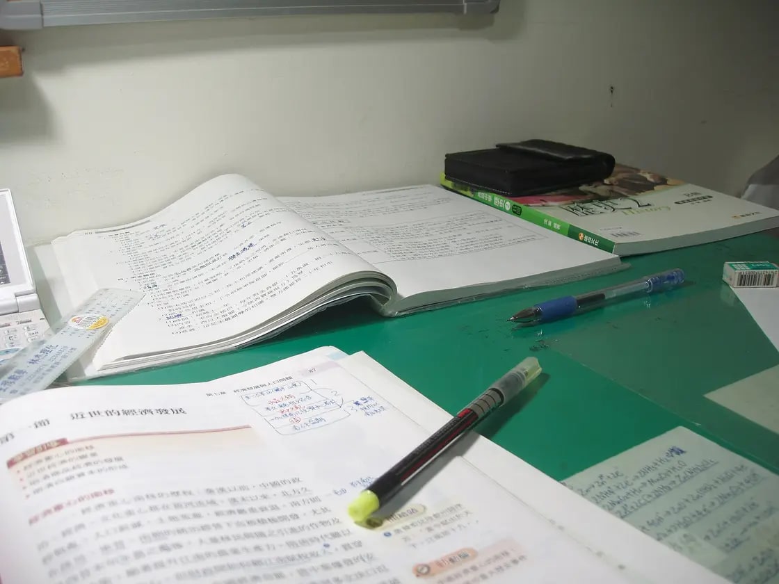 A stack of used college textbooks on a desk
