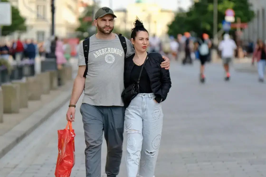 A couple walking arm in arm along a busy street