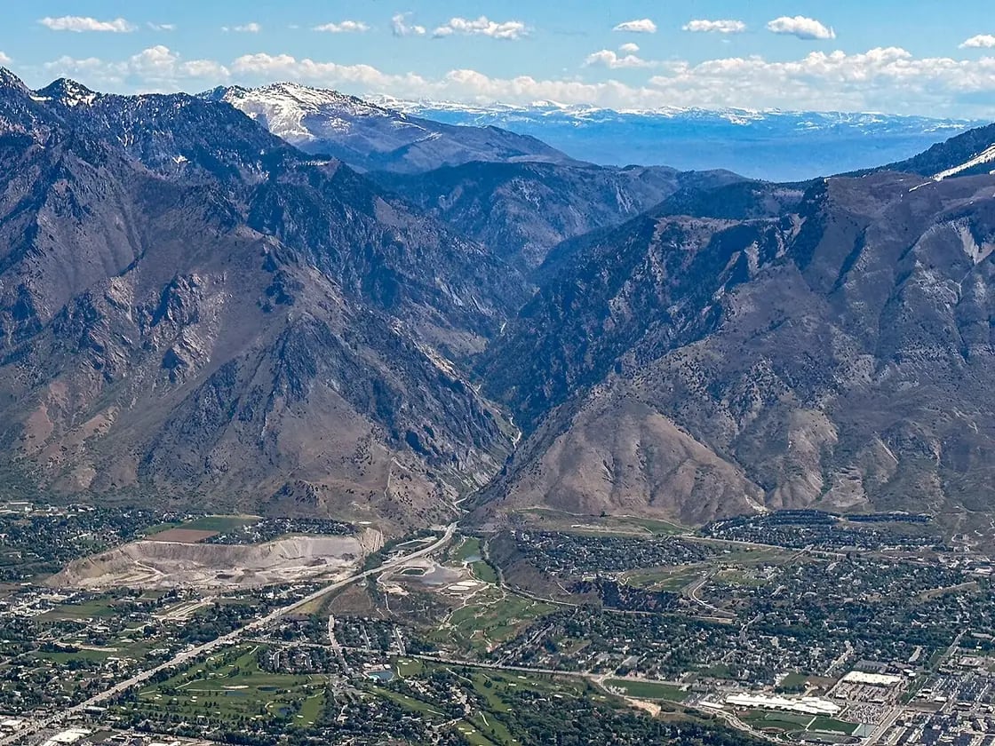 An aerial view east into the mouth of Provo Canyon, with the Utah Valley floor below and the Wasatch Range beyond